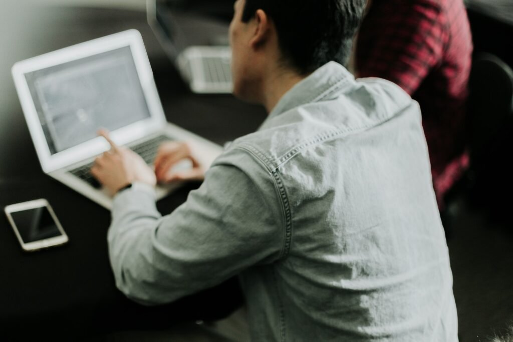 A man sitting at a table using a laptop computer