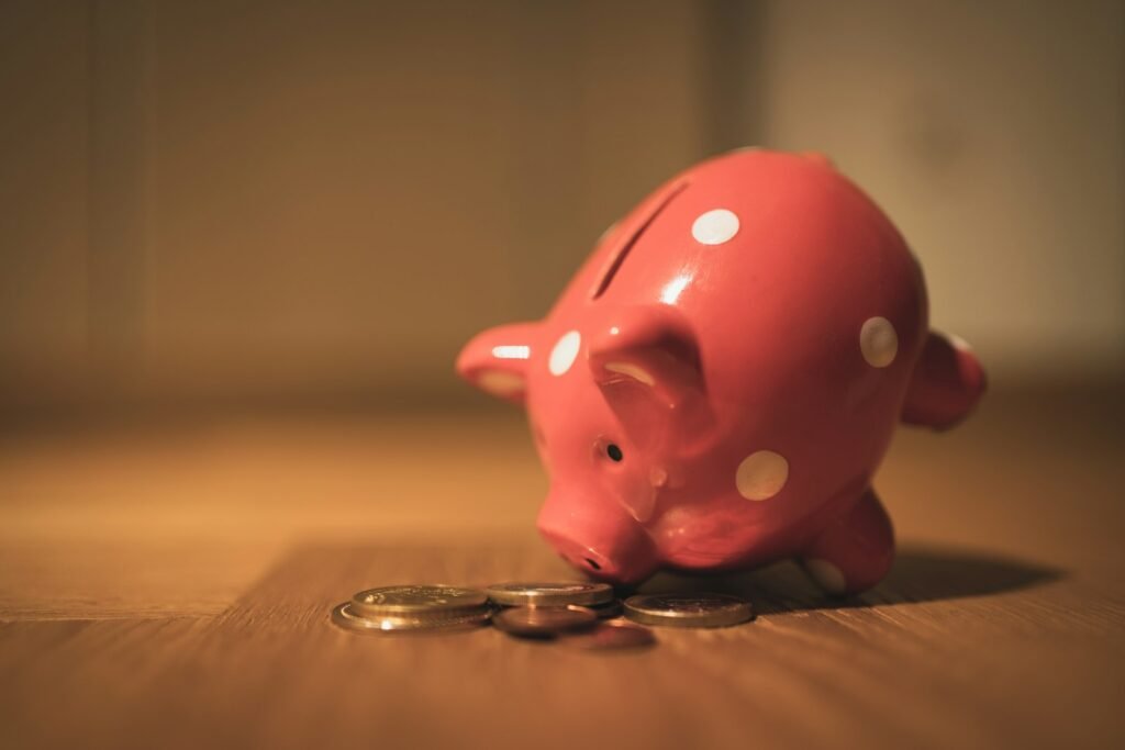 Pink pig coin bank on brown wooden table